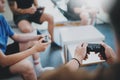 Group of best friends sitting on a sofa in living room and playing video games. Family relaxing time at home concept. Royalty Free Stock Photo