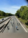 Group of bicyclists cycling down a highway on a sunny day