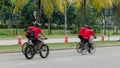 Group of bikers ride along city road, four men on bicycles ride down street