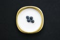 Group of bilberries placed on a golden dish with black isolated