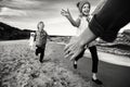 Three funny smiling laughing Caucasian children kids friends playing running on ocean sea beach Royalty Free Stock Photo