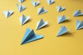 Group of blue paper aeroplane origami on yellow background