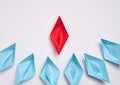 A group of blue paper boats surrounded one red boat, the concept of bullying, search for compromise. Top view