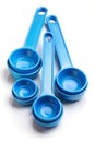 A Group of Blue Plastic Measuring Spoons and Scoops on a White Background kitchenware cooking Royalty Free Stock Photo