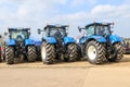 A group of blue tractors parked up Royalty Free Stock Photo