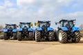 A group of blue tractors parked up