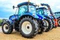 A group of blue tractors parked up