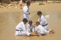 A group of boys dressed in Taekwondo uniforms are playing in the sand on Tlangoh Beach, Bangkalan, Madura, East Java