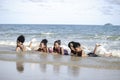 Group of boys and girls lie down in shallow sea water, cute kids having fun on sandy summer beach, happy childhood friend playing Royalty Free Stock Photo