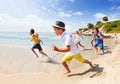 Group of boys and girls run along the sea beach