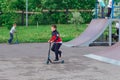 Group of boys ride a scooter in an extreme park. Study of extreme sports on the open air.