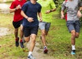 Group of boys running together on grass path