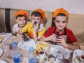 Group of boys by the table eating burgers which have been cooked by themselves. Master class about cooking fast food.