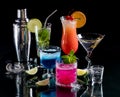 A group of bright colourful cocktails on glass against a black background.