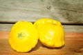 Group of bright yellow patty pans on a wooden chopping board. Selective focus