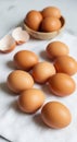 A group of brown eggs is arranged on a white cloth, with a few open eggshells nearby Royalty Free Stock Photo