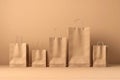 Group of brown paper shopping bags isolated on beige background, mock up, no brand, consumer and online shopping concept. Royalty Free Stock Photo