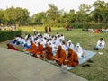 A group of Buddhist monks and pilgrims praying at an ancient monastery in Sarnath