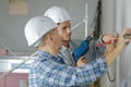 Group builders in hardhats with electric drill indoors Royalty Free Stock Photo