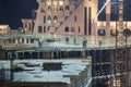 Group of building workers working on illuminated construction site at night