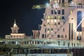 Group of building workers working on illuminated construction site at night