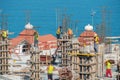 Group of building workers working on the top of the construction site with blue sea background