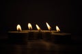 Group of burning small candles on a black background.