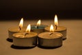 Group of burning small candles on a black background. Royalty Free Stock Photo