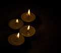 Group of burning small candles on a black background. Royalty Free Stock Photo