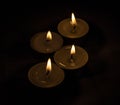 Group of burning small candles on a black background. Royalty Free Stock Photo