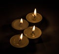 Group of burning small candles on a black background. Royalty Free Stock Photo