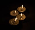 Group of burning small candles on a black background. Royalty Free Stock Photo