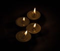 Group of burning small candles on a black background. Royalty Free Stock Photo