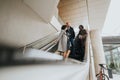 Three multiracial businesspeople in winter coats discussing on an escalator inside a contemporary office building Royalty Free Stock Photo