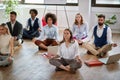 Group of business coworkers meditating at work, sitting on the floor. modern, business, meditation concept Royalty Free Stock Photo