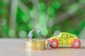 Group of business man Miniature people, small model human figure sell or buy wooden yellow car and stack of gloden coins with