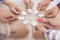 A group of business people assembling jigsaw puzzle. The concept of cooperation, teamwork, help and support in business. Team Royalty Free Stock Photo