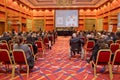 Man with headset at the conference . The audience wearing head phone for online translation . Unrecognizable people using in ear