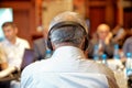 Group of business people attending press conference or presentation. Unrecognizable people using in ear headphones for translation