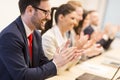 Group of business people clapping their hands at the meeting