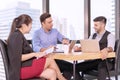 Business people colleagues talking about planning project in the workplace. Man holding pen with colleagues sitting on desk Royalty Free Stock Photo