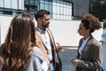 Group of business people discussing ideas at meeting outside. Businesswoman and businessman outdoor near office building talking Royalty Free Stock Photo