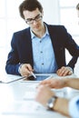 Group of business people discussing questions at meeting in modern office. Headshot of businessman at negotiation