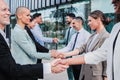 group of business people greeting each other with a handshake in workspace. Businessmen and businesswomen making a Royalty Free Stock Photo