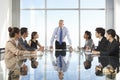 Group Of Business People Having Board Meeting Around Glass Table