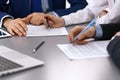 Group of business people and lawyer discussing contract papers sitting at the table, closeup. Businessman is signing Royalty Free Stock Photo