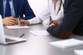 Group of business people and lawyer discussing contract papers sitting at the table, closeup. Businessman is signing