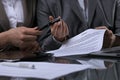 Group of business people and lawyers discussing contract sitting at the table. Woman chief is taking pen for signing Royalty Free Stock Photo