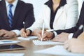 Group of business people or lawyers work together at meeting in office, hands using tablet and making notes close-up