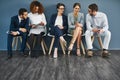 Group of business people networking on phones, digital tablets and social media, waiting in line. Diverse team of Royalty Free Stock Photo